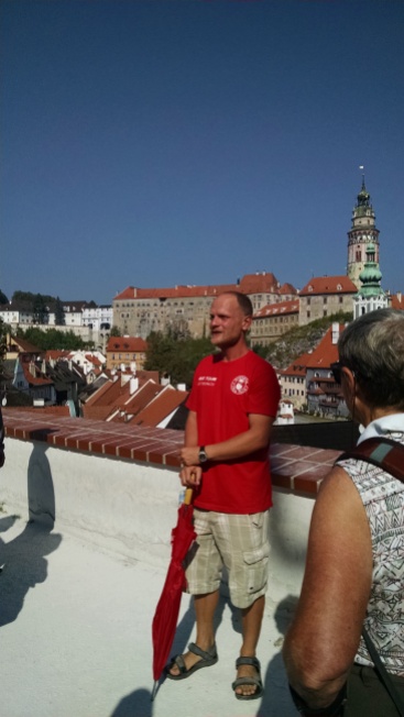 Walking tour guide with view of castle behind him.